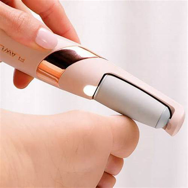 Hand holding a small electronic device with a rose gold and beige design on a light background