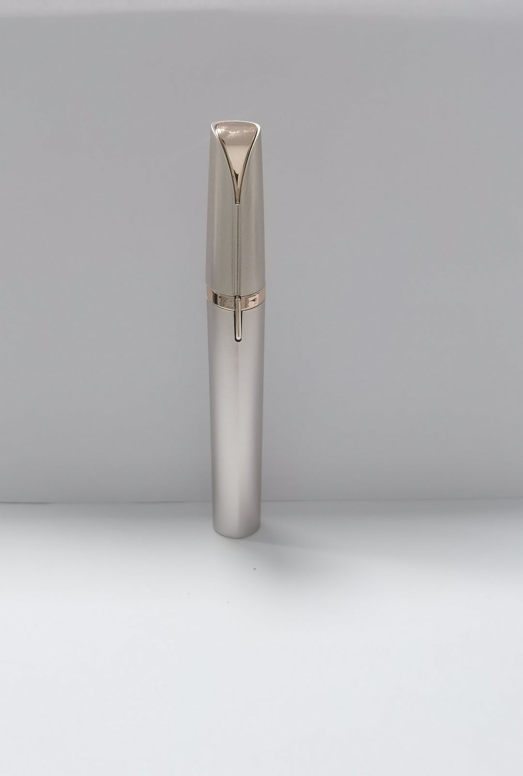 Silver pen with rose gold accents on a light gray background