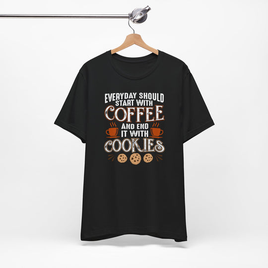 Black t-shirt with coffee and cookies graphic on a hanger against a white background
