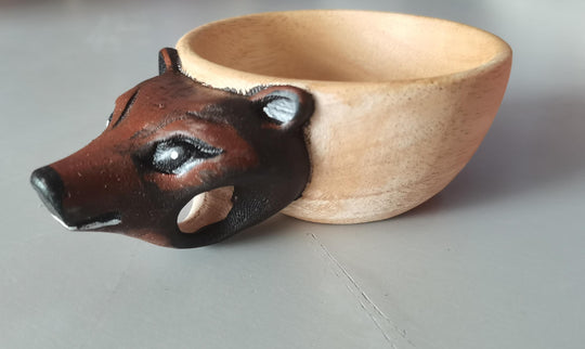 Wooden bowl with a fox face design on a gray background