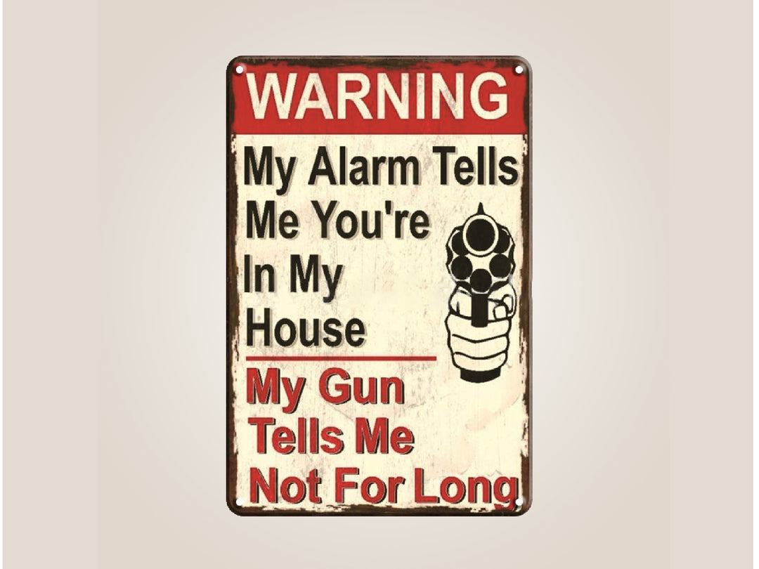 Metal sign with humorous warning text and a gun graphic on a beige background