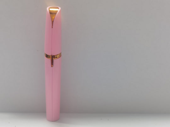 Pink pen with gold accents on a white background