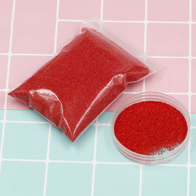 Red sand in a clear plastic bag and container on a tiled surface