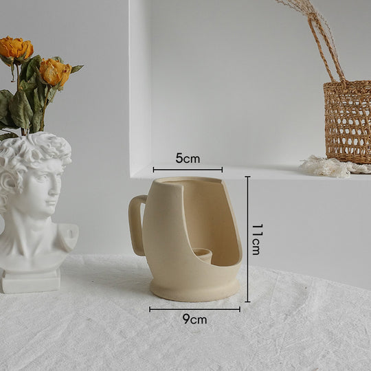 Beige ceramic mug with dimensions labeled on a white surface.
