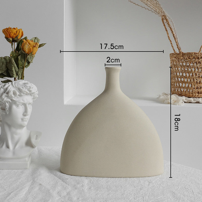 Beige ceramic vase with measurements on a light gray surface