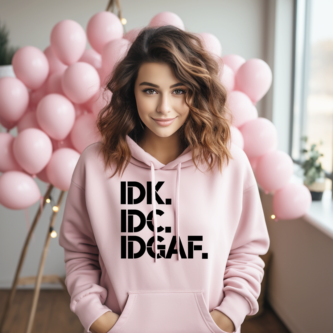 Person wearing a pink hoodie with text in front of pink balloons