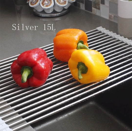 Three bell peppers on a silver rolling tray over a kitchen sink.