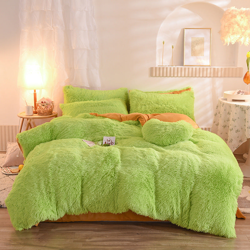 Green fluffy bedding set on a bed in a bedroom setting.