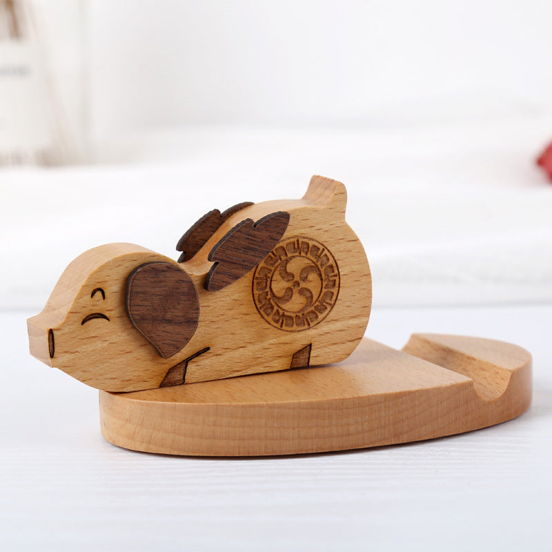 Wooden elephant-shaped object with engraved design on a white surface