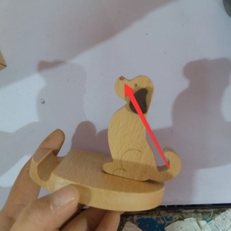 Wooden snake toy with a hand holding it, on a light background