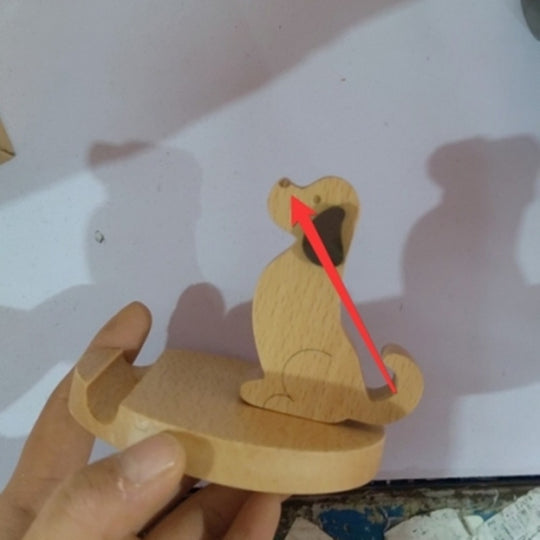 Wooden snake toy with a hand holding it, on a light background