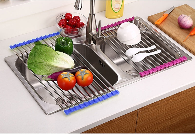 Kitchen sink with a stainless steel rack holding vegetables and cutlery on a kitchen counter.