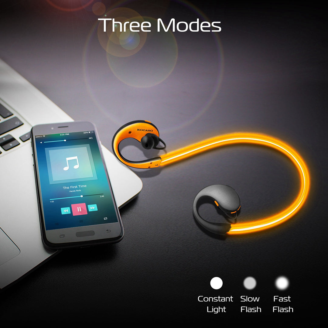 Wireless earbuds with smartphone displaying music app on a dark surface