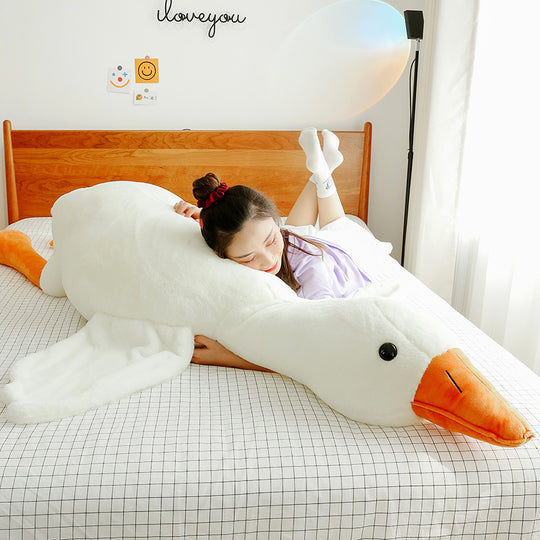 Person lying on a large swan-shaped pillow with &