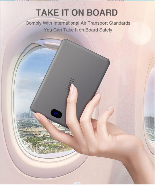 Hand holding a small device with airplane window and sky view in the background, promoting safety on board.
