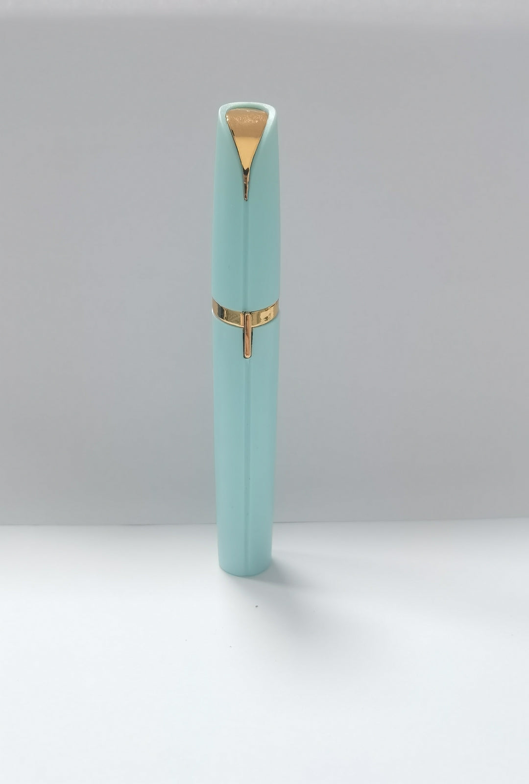 Light blue pen with gold accents on a white background