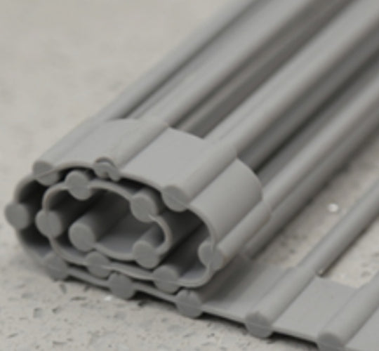 Stack of gray plastic profiles on a concrete surface