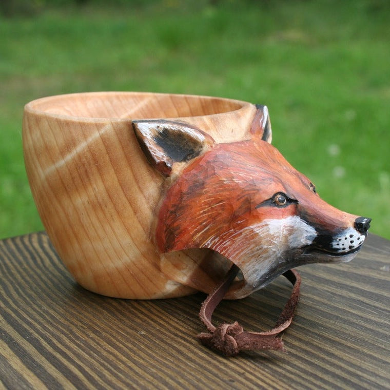 Wooden cup shaped like a fox with a natural wood finish on a wooden surface.