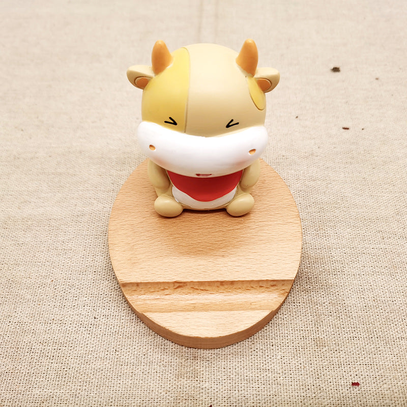 Small animal figurine on a wooden stand against a beige fabric background