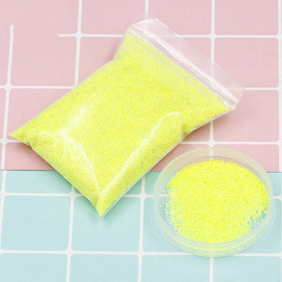 Clear bag with yellow beads on a pink and blue checkered background