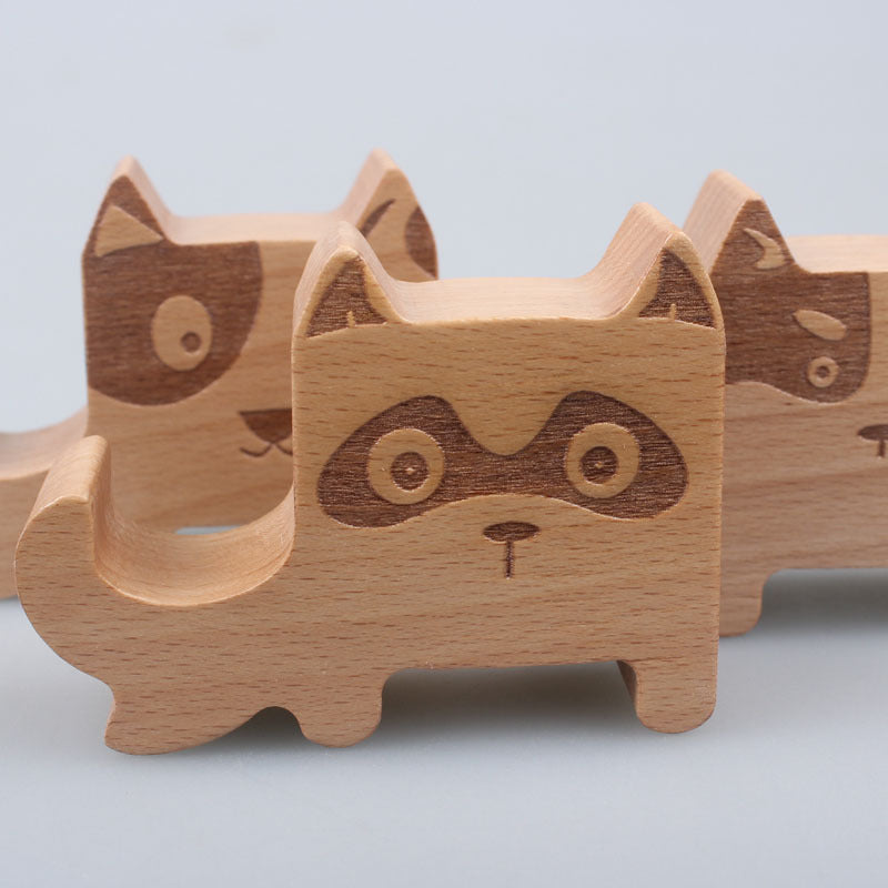 Wooden raccoon figurines on a light gray background