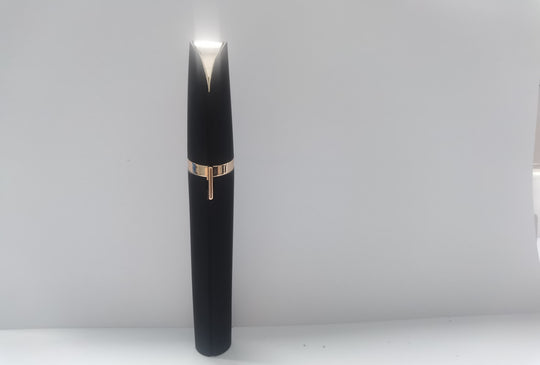 Black pen with gold accent on a white background