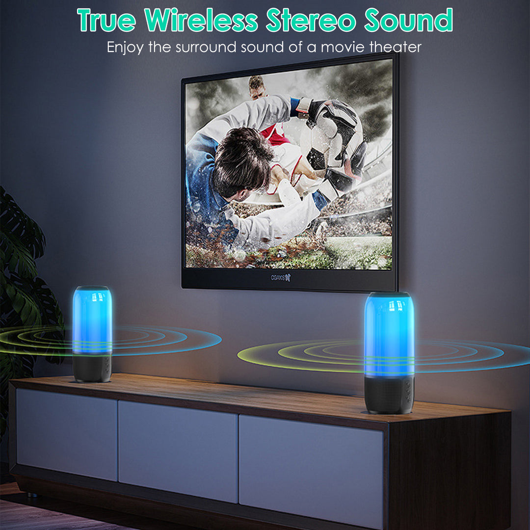 Two blue and black speakers on a wooden cabinet with a TV displaying a movie scene in the background.
