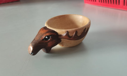 Wooden bowl shaped like a bear on a gray surface