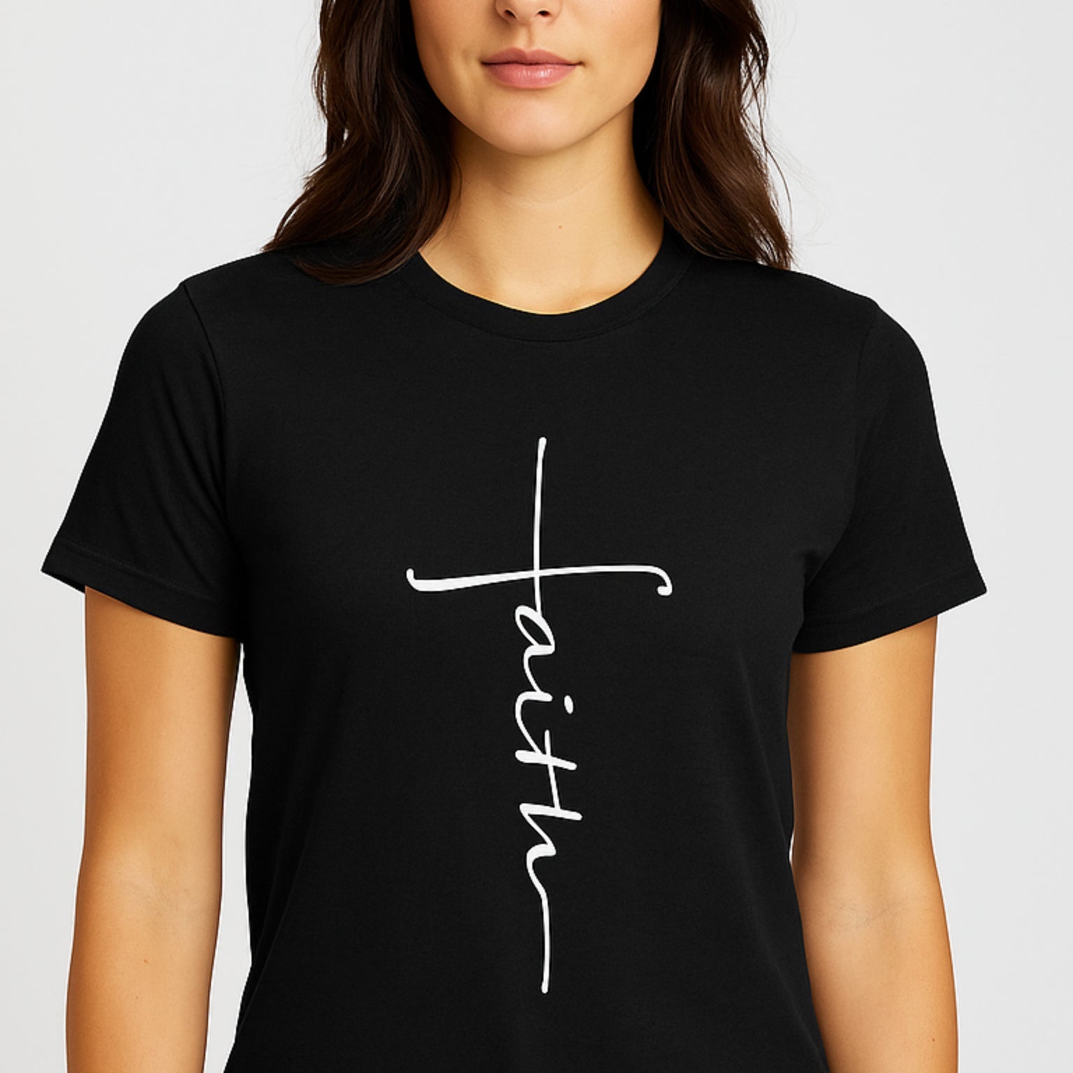 Black t-shirt with 'faith' printed on it worn by a person against a plain background