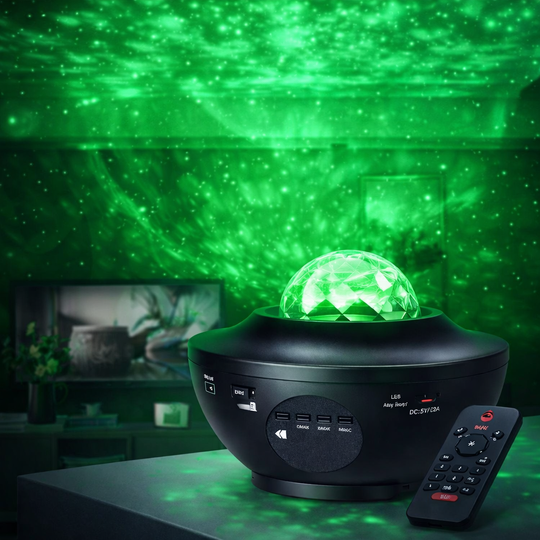Black night light projector with green starry sky effect on a table.