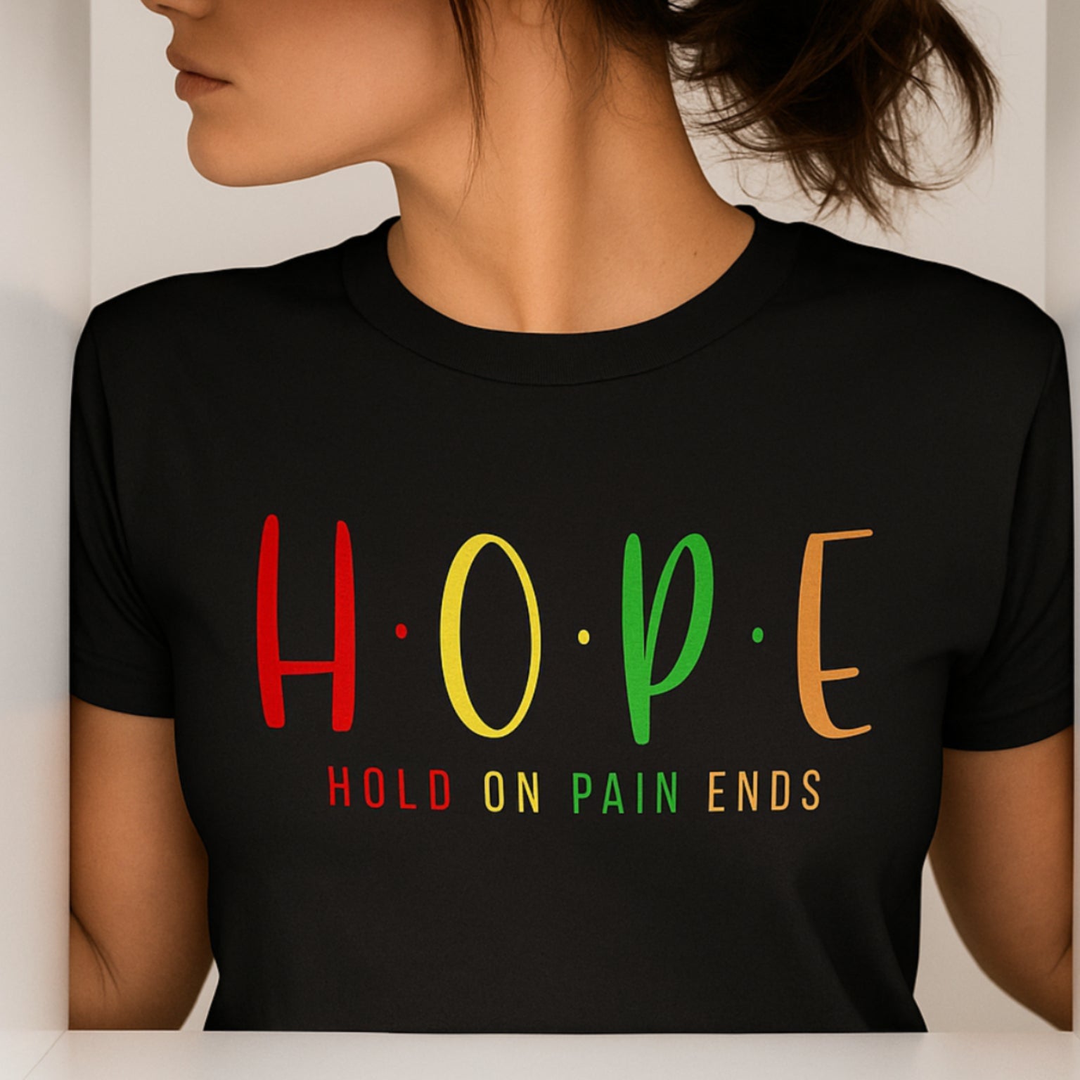 Person wearing a black t-shirt with 'HOPE Hold on Pain Ends' text in colorful letters.