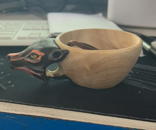 Wooden bowl with a bear head design on a desk