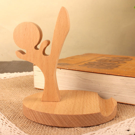 Wooden sculpture of a figure with outstretched arms on a textured surface