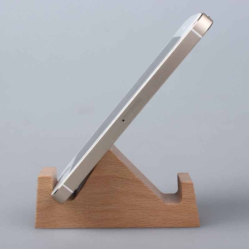 Wooden phone stand holding a smartphone on a gray background