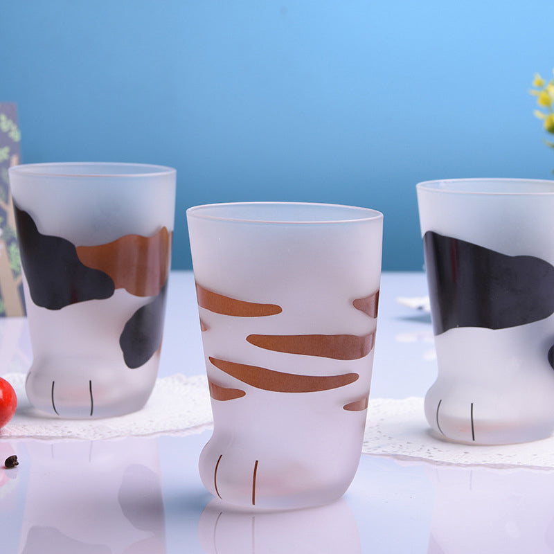 Three glass cups with cat paw designs on a blue background
