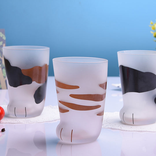 Three glass cups with cat paw designs on a blue background