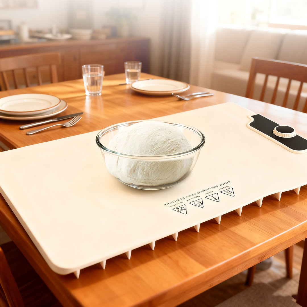 Heated mat on a wooden table with a bowl of food, glasses, and a phone.