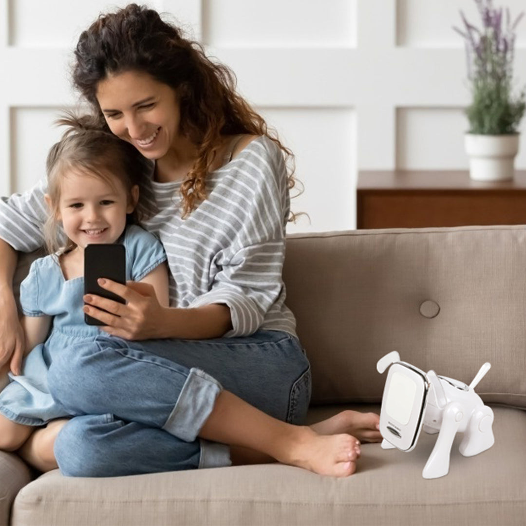 Woman and child sitting on a couch with a smartphone, next to a white robot dog.