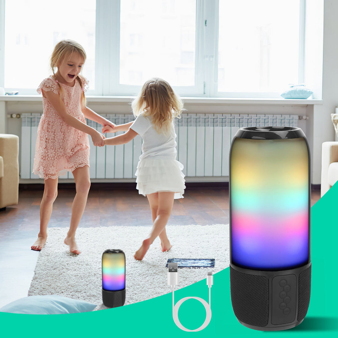 Two children holding hands in a room with a colorful cylindrical light and its packaging.