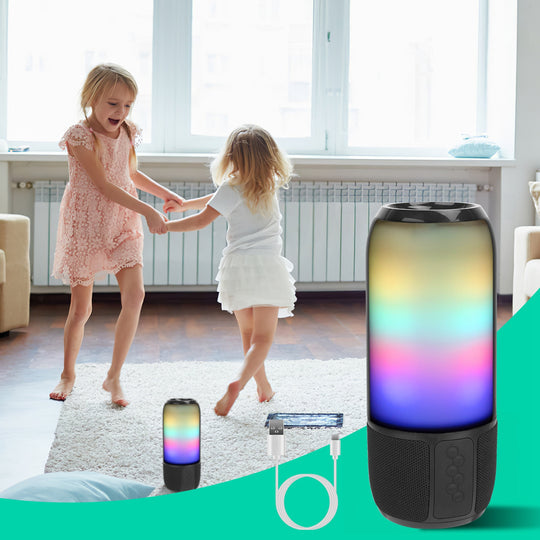 Two children holding hands in a room with a colorful cylindrical light and its packaging.