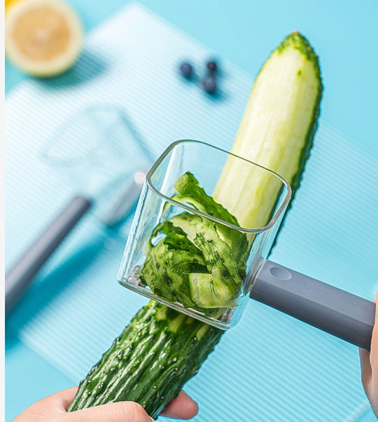 Stainless steel peeler peeling a cucumber in a bright kitchen