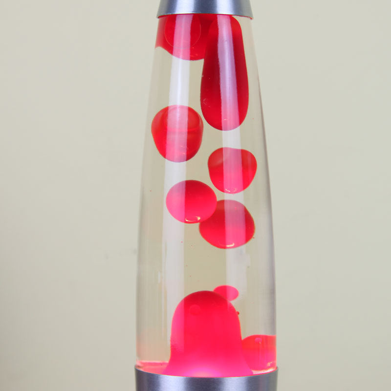 Lava lamp with red and clear liquid on a beige background
