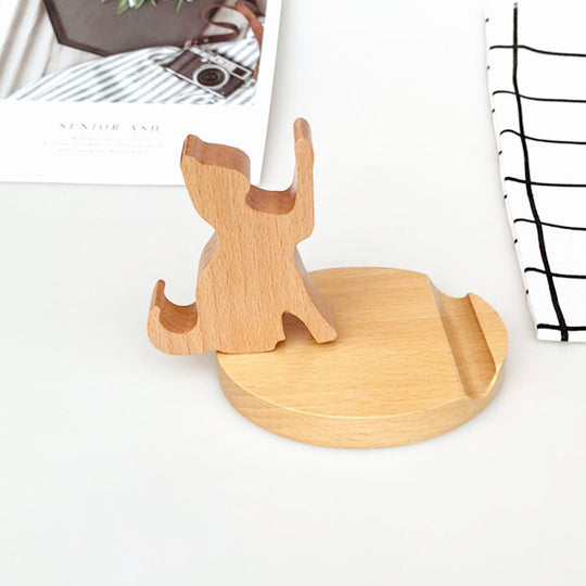 Wooden phone stand shaped like a dog on a white surface