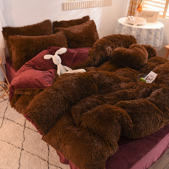 Brown fuzzy blanket draped over a bed with pillows and a stuffed animal in a cozy room.