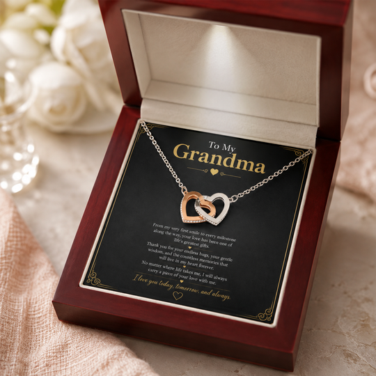 A heart-shaped double-ring pendant necklace presented in an open dark wood gift box with a printed message card addressed &