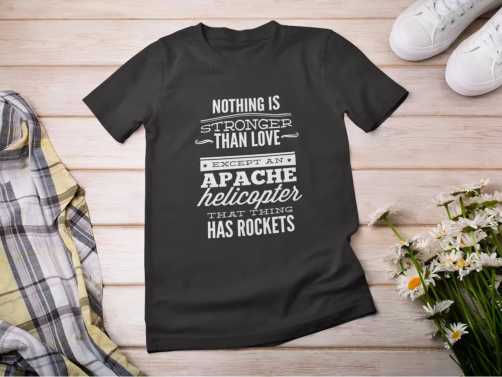 Black t-shirt with humorous text design on a wooden surface with shoes and flowers.