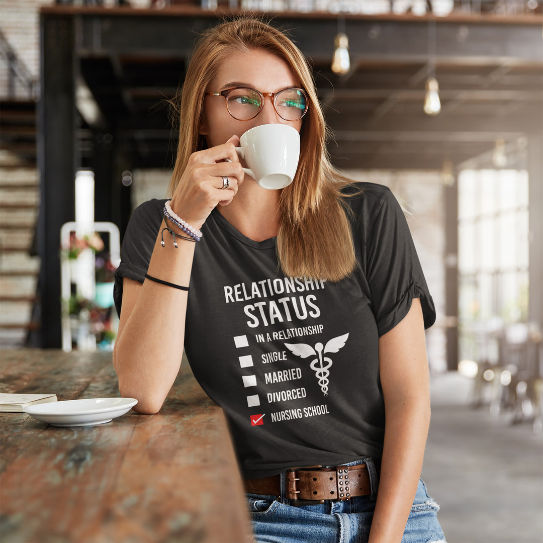 Woman drinking from a white mug wearing a black t-shirt with a humorous relationship status graphic.