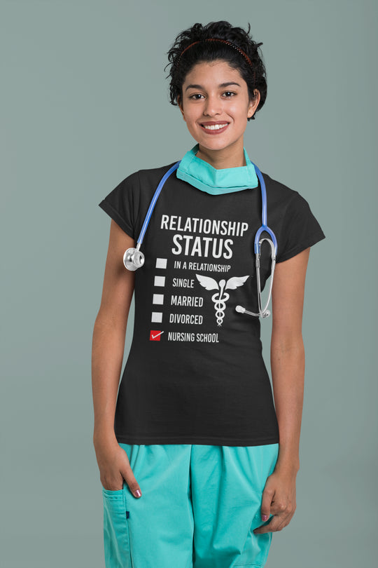 Person wearing a black t-shirt with a humorous relationship status graphic and teal scrubs on a gray background